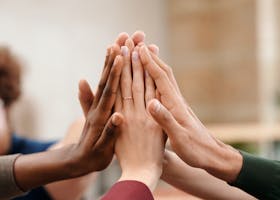 Close-up of diverse group hands high-fiving symbolizing teamwork and unity.